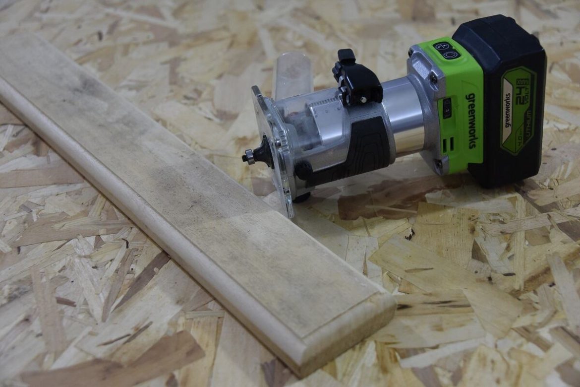 аккумуляторный фрезер Greenworks G24RO на фоне доски с кромкой аккумуляторный фрезер Greenworks G24RO